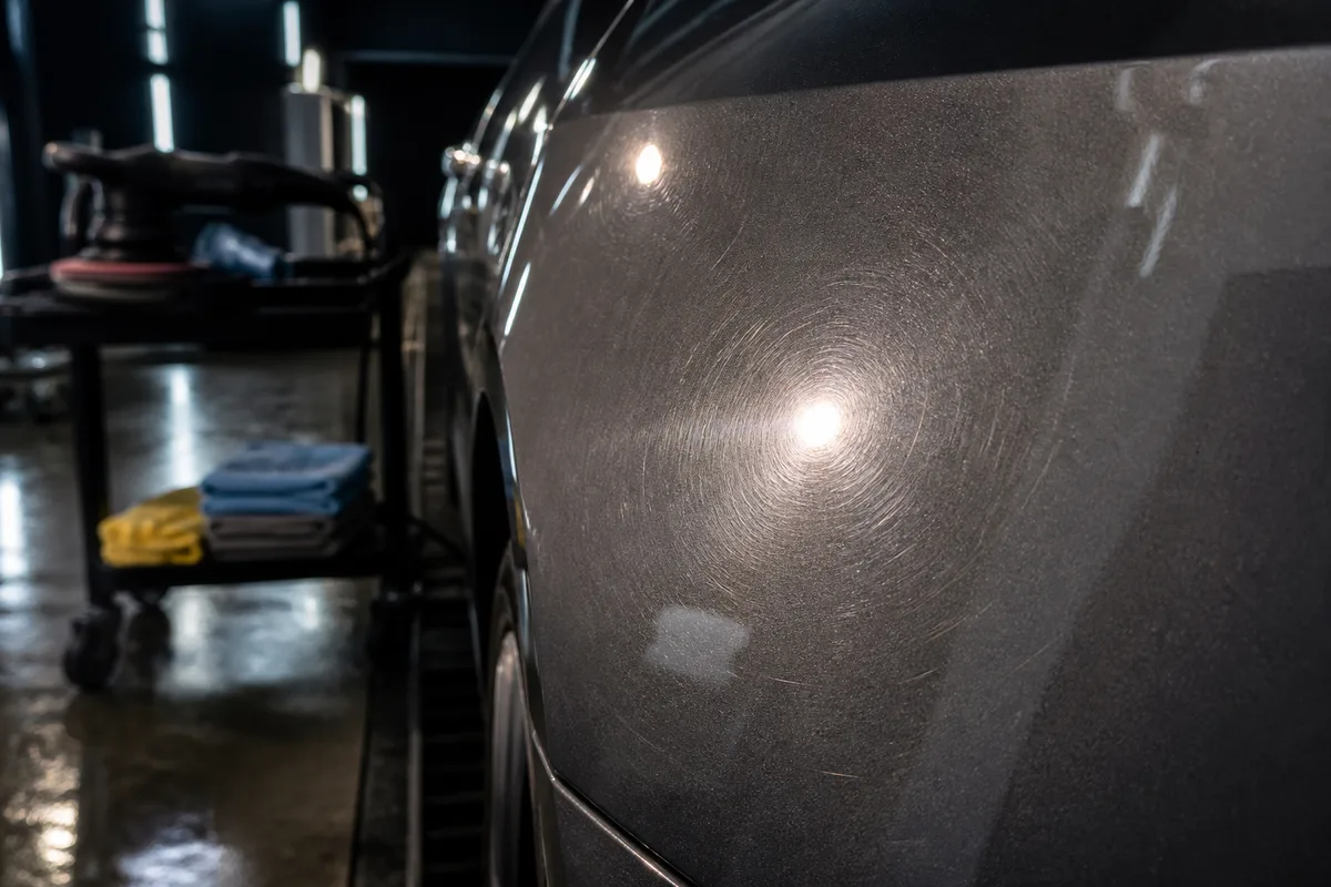 Carrosserie grise éclairée en rasance révélant les micro-rayures avant traitement